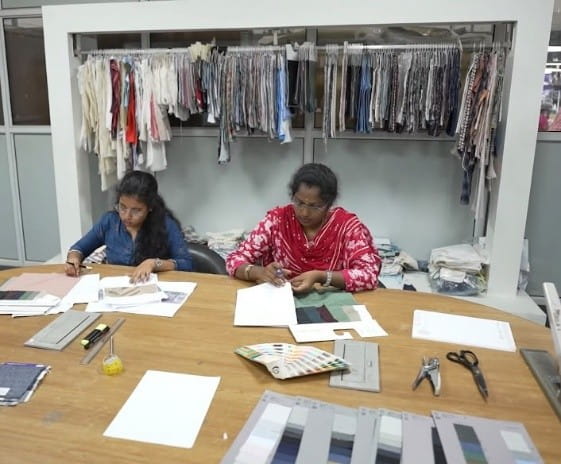 Design team reviewing fabrics, sketches and colour references