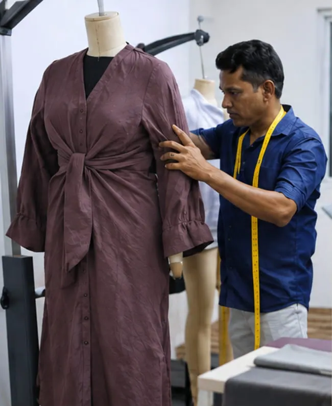 Pattern maker fitting a sample on a dress form
